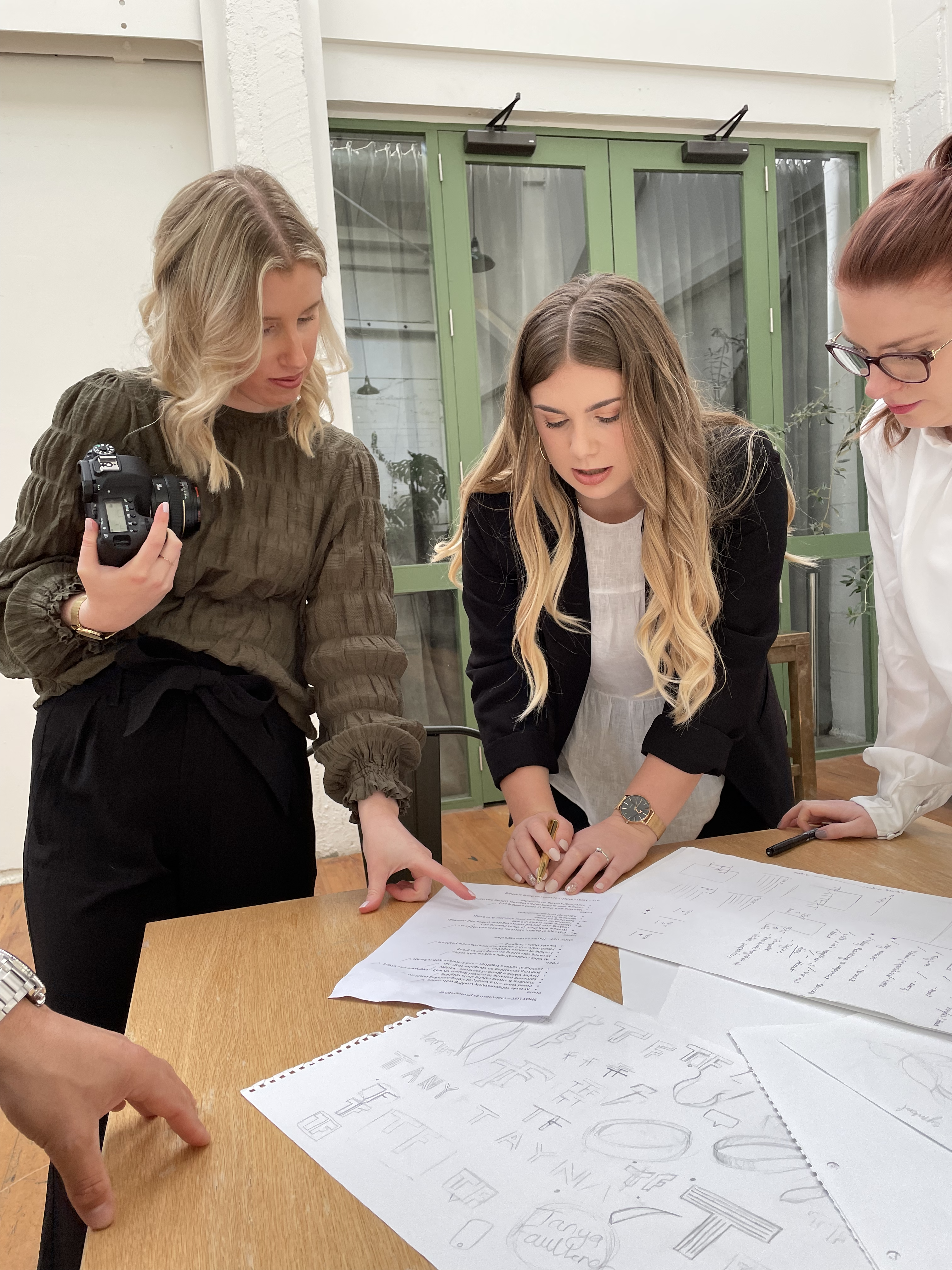 Islay and Hayley looking over photography plan documents at a table